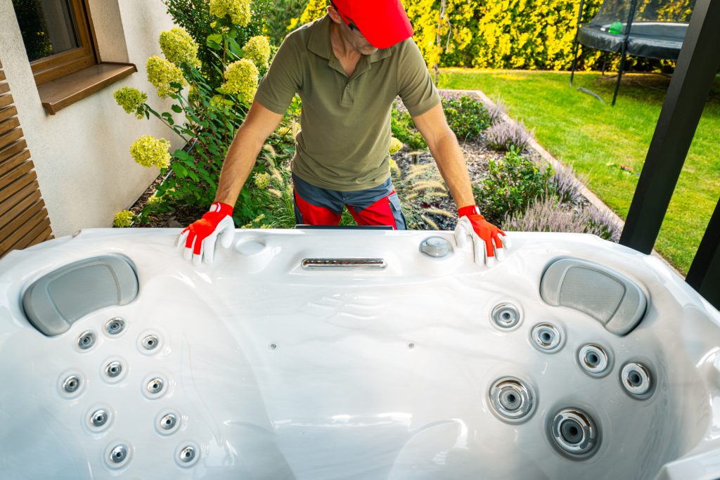 Spa installation man looking over a swim spa outside in a backyard